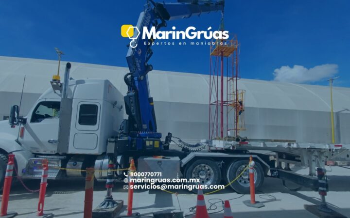Grúa HIAB realizando el montaje de una estructura metálica en una instalación industrial.