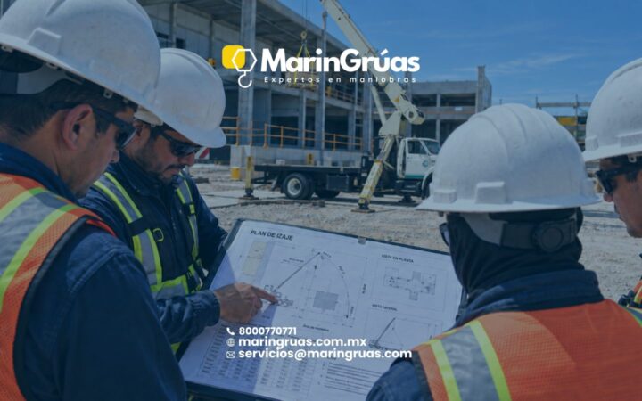 Cuadrilla de maniobras revisando el croquis del plan de izaje junto a la grúa antes de iniciar.