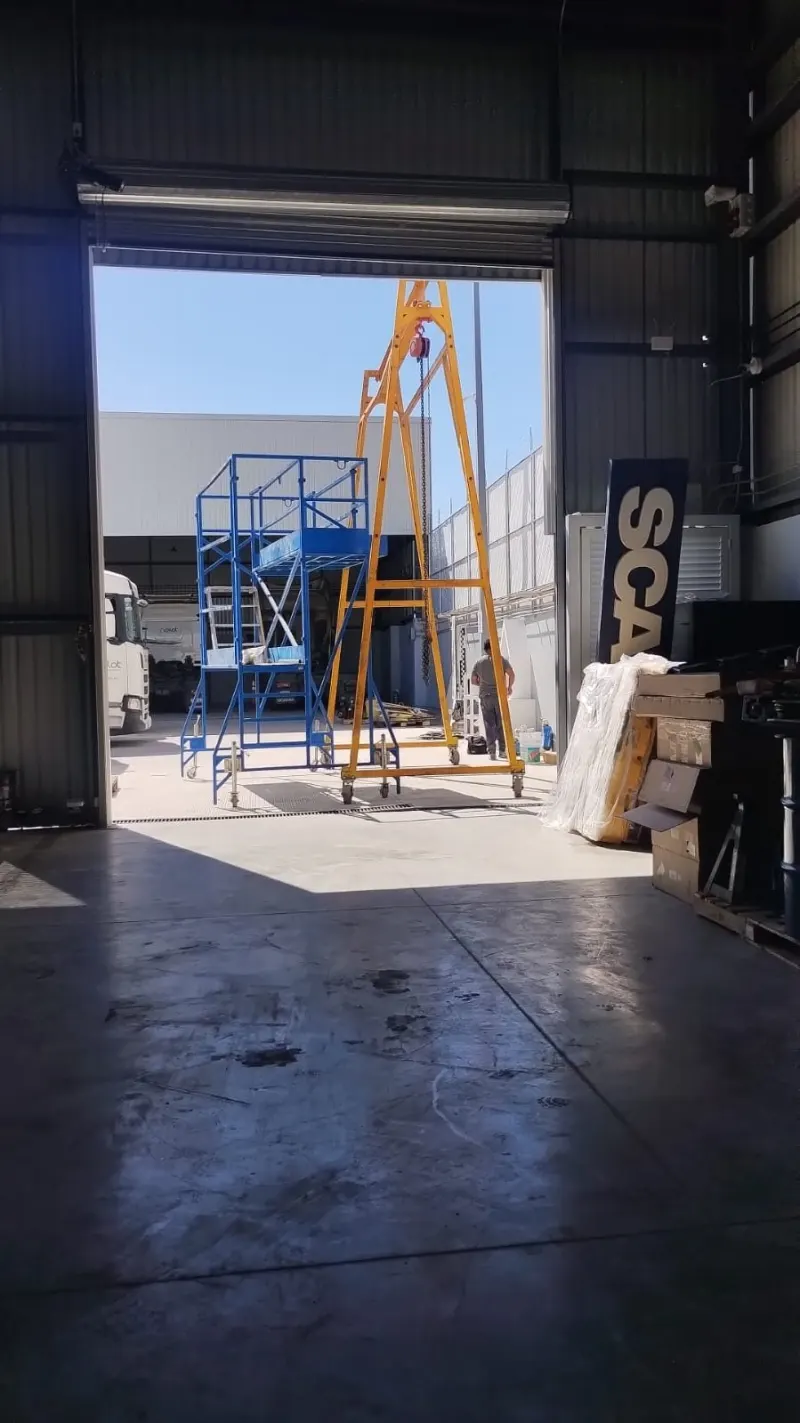 Estructura metálica amarilla colocada junto al acceso abierto de la nave.
