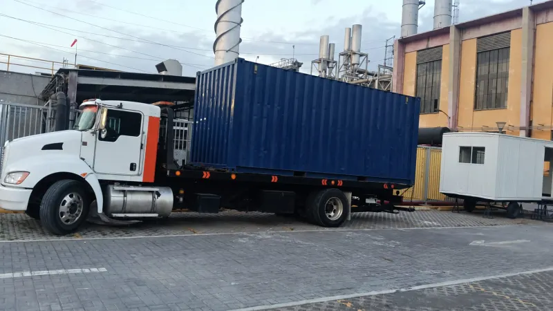 Plataforma de 6 metros con contenedor de 9.5 toneladas cargado, dentro de una planta industrial