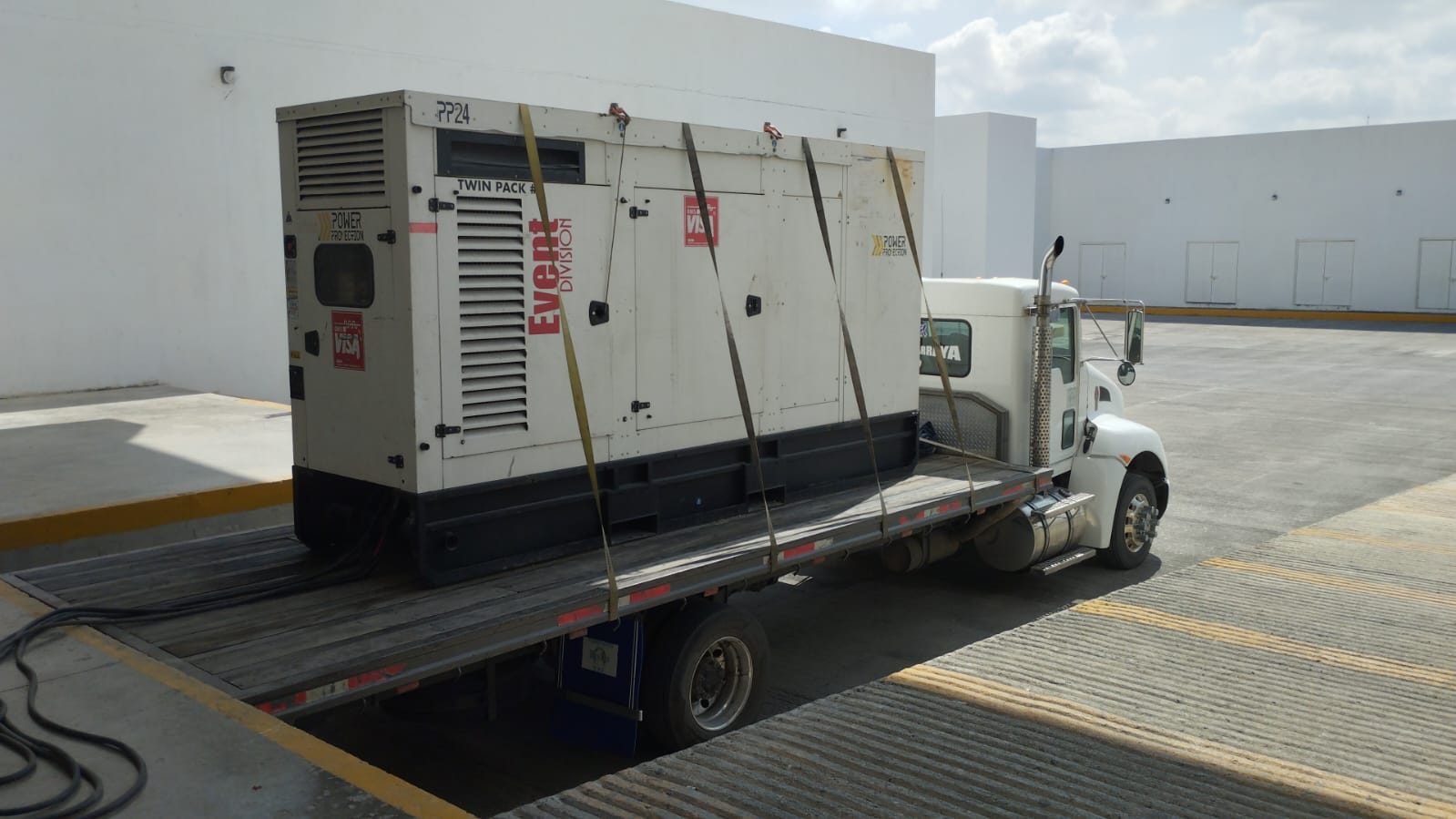 Planta generadora asegurada con bandas sobre una plataforma de transporte.