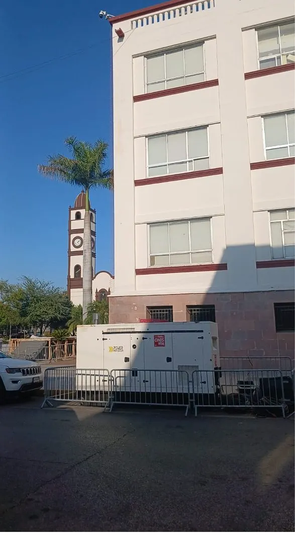 Planta de luz asegurada con cinchos sobre la plataforma de un camión estacionado en la vía pública.