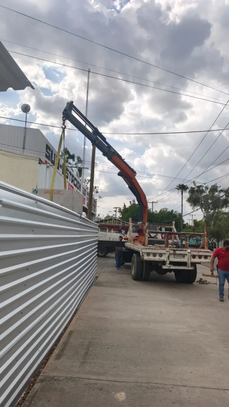 Dos registros de concreto y rollos de ducto naranja asegurados sobre la plataforma del camión.